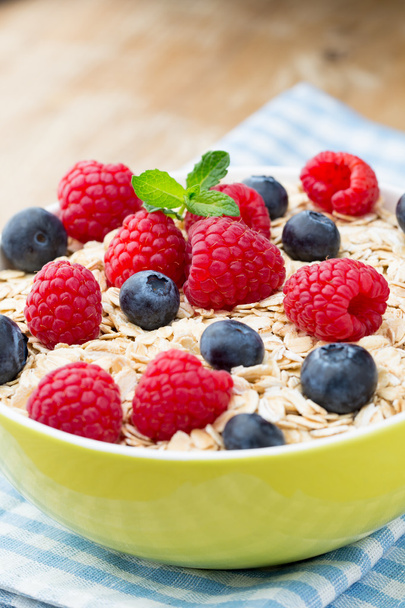 Oatmeal porridge with berries. Raspberries and blueberries. - 写真・画像
