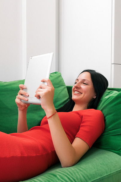 Smiling beautiful woman  using tablet on sofa - Zdjęcie, obraz