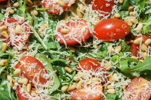 Salad with arugula, spinach, tomatoes, parmesan and pine nuts - Foto, Bild