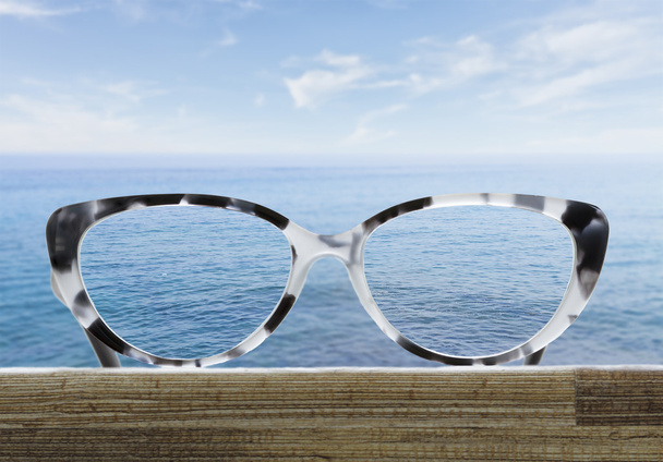 glasses on a wooden table in front of the sea - Foto, Bild