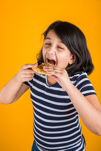 retrato de linda chica india comiendo pizza sobre fondo amarillo
 - Foto, Imagen