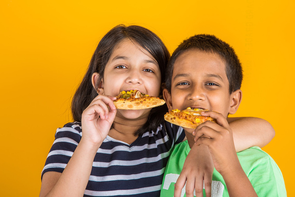 Intialainen poika ja tyttö syö pizzaa, aasialainen lapset syövät pizzaa
 - Valokuva, kuva