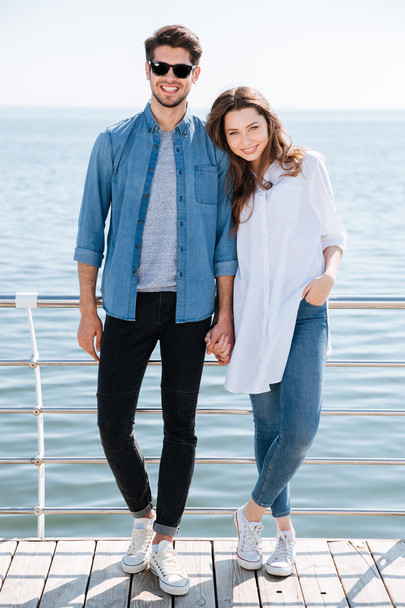 Full length of a young couple standing together holding hands - Foto, Bild