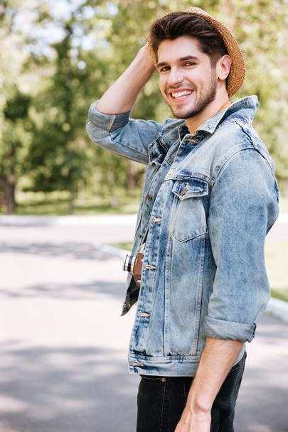 Close-up portrait of a handsome guy holding camera outdoors - Fotografie, Obrázek