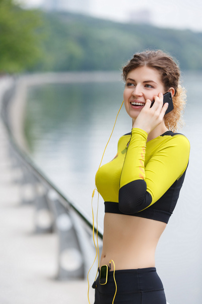 Young woman in sportswear talking on mobile phone - Foto, Bild