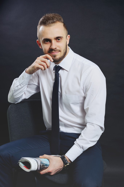 Successful businessman. Portrait of confident young man in formalwear looking at camera and smiling while keeping arms crossed and standing against grey background - Foto, imagen