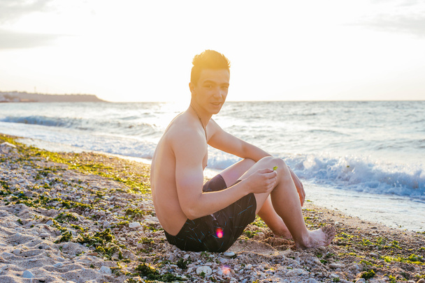 Man sitting on beach - Фото, зображення