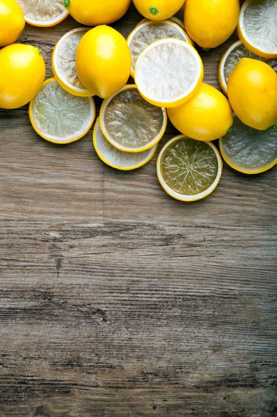 Fresh ripe lemons on wooden board background with copy space - Фото, зображення