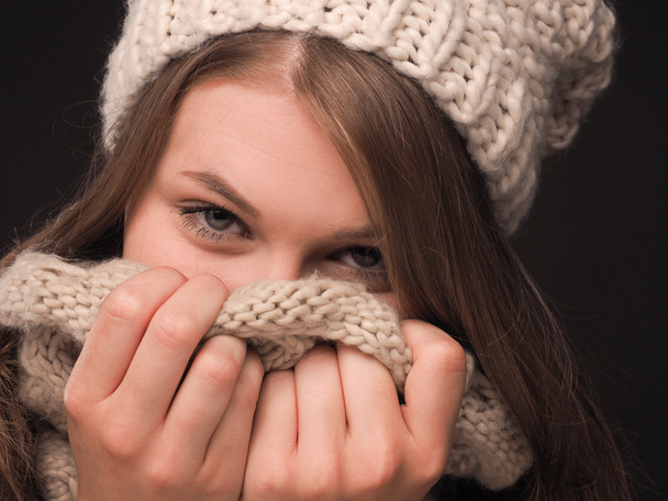 Atractiva joven mujer escondiendo su cara con una bufanda
 - Foto, imagen