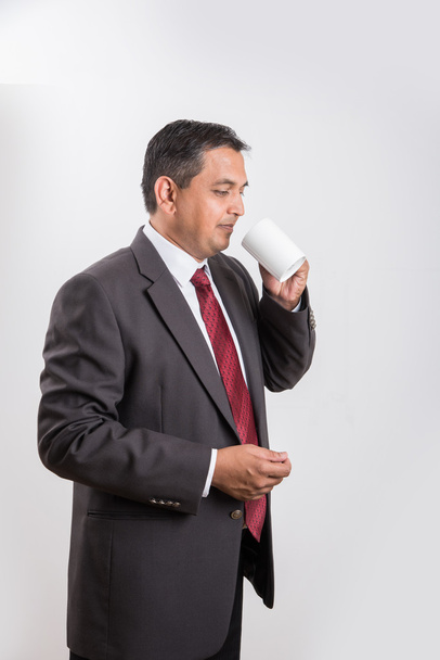 hombre de negocios indio tomando café o té, hombre de negocios asiático y café o té, hombre de negocios bebiendo café en taza blanca grande, aislado sobre fondo blanco, vista lateral
 - Foto, imagen