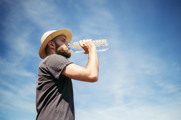Man drinking water in nature - Фото, изображение