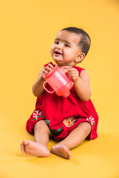 Kırmızı arka plan üzerinde sevimli küçük Hint bebek kız oynamak oyuncaklar, Hint bebek kız oynamaktan, Asya bebek oyun oynarken Hint yürümeye başlayan çocuk - Fotoğraf, Görsel