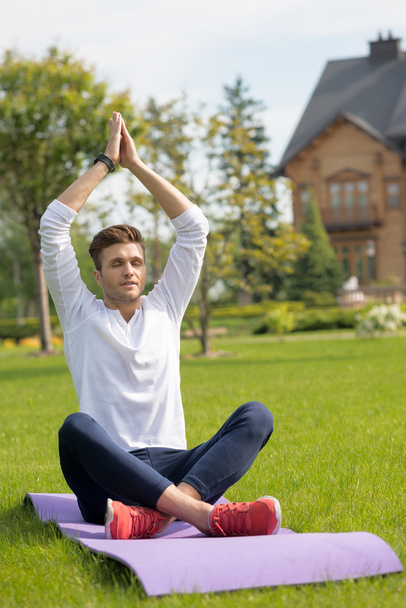 Relaxed male athlete meditating on grass - Photo, Image