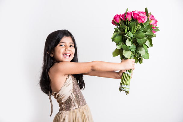 indian little girl holding bouquet or red rose flowers, asian girl with flowers, little indian girl with bunch of red roses - Photo, Image