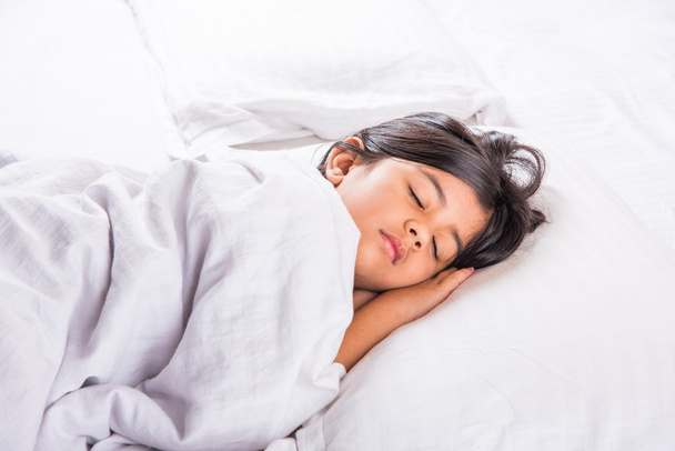 cute Indian Girl sleeping over white pillow, small asian girl sleeping on bed - Photo, Image