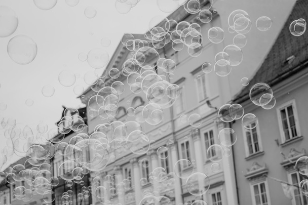 Мильні бульбашки на тлі старого міста
 - Фото, зображення