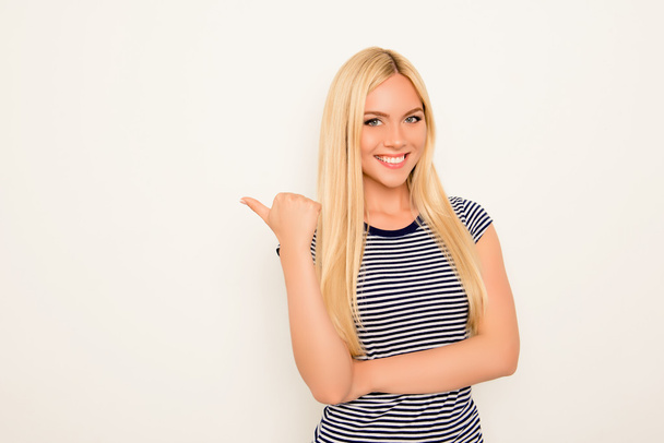 Cheerful young woman showing way on white background - Fotoğraf, Görsel