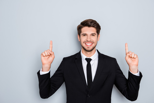 Handsome smiling man in suit gesturing up with fingers - Foto, Imagem