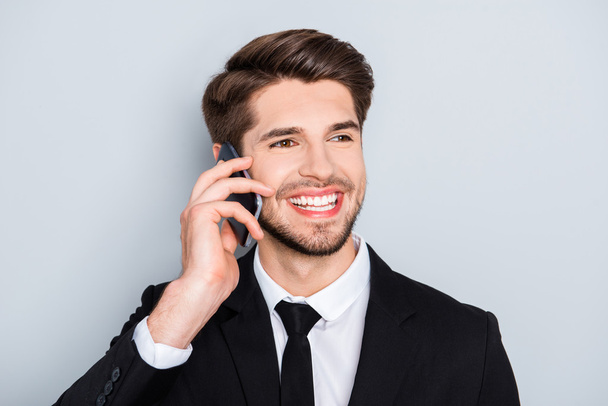 Portrait of handsome smiling businessman talking on smartphone w - 写真・画像