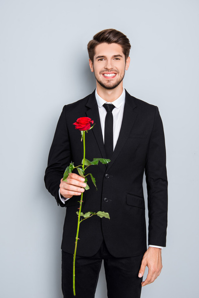 Portrait of handsome happy man holding red rose - Foto, afbeelding