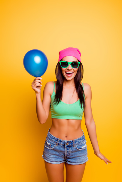 Cheerful excited hipster girl in pink hat  holding balloon on ye - Photo, image