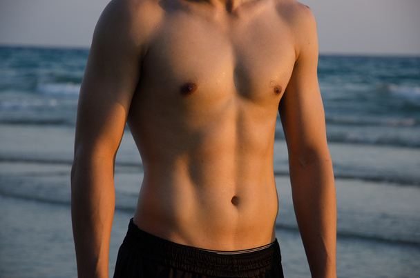Torso of strong man against sunset - Photo, Image