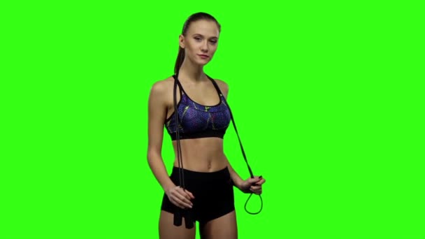 Woman holding jump rope on her shoulders. Slow motion. Green screen - 映像、動画