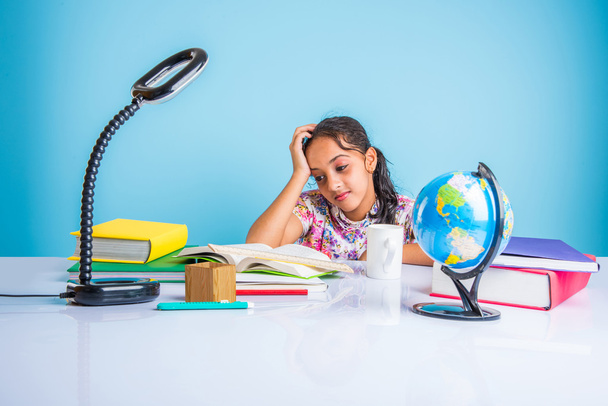 educación y concepto de hogar - estudiante estresada chica con libros, niña india niño cansado de estudiar o hacer tareas, chica asiática estudiando y estresado, con globo juguete y taza de café
 - Foto, imagen