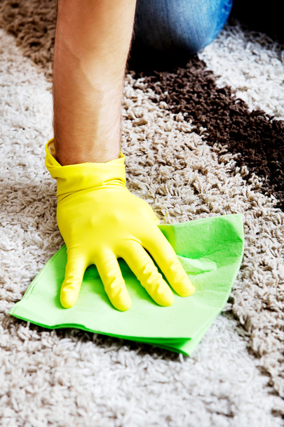 Man in yellow gloves cleaning carpet - Foto, Bild