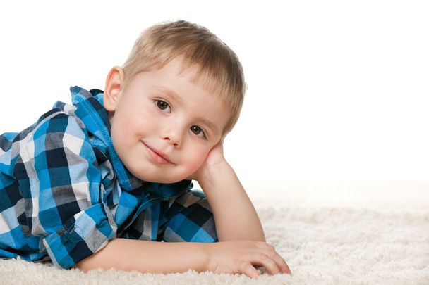 Little boy in a checked shirt on the carpet - Фото, изображение