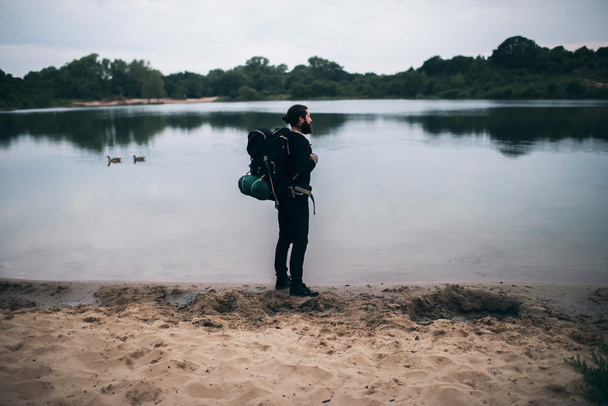 Backpacker standing at dune   - Фото, зображення