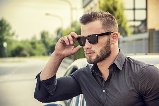 Handsome bearded man next to car in sunglasses - Foto, Imagem