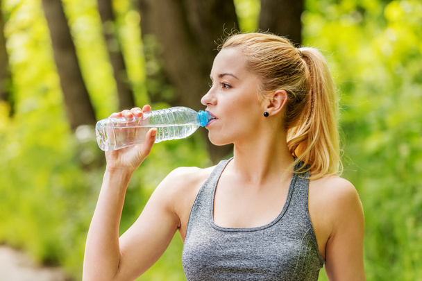 sportieve vrouw drinkwater. - Foto, afbeelding