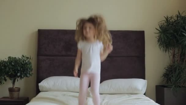 Little girl jumping on the bed at home - Video, Çekim