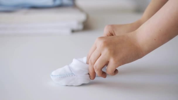 woman hands with baby bootees   - Video
