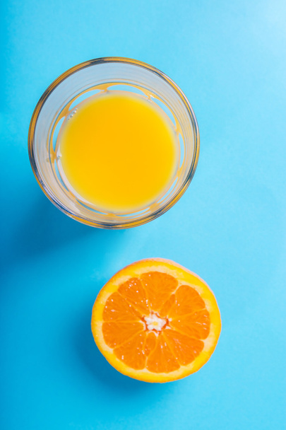 Glass of orange juice and half of orange - Foto, afbeelding