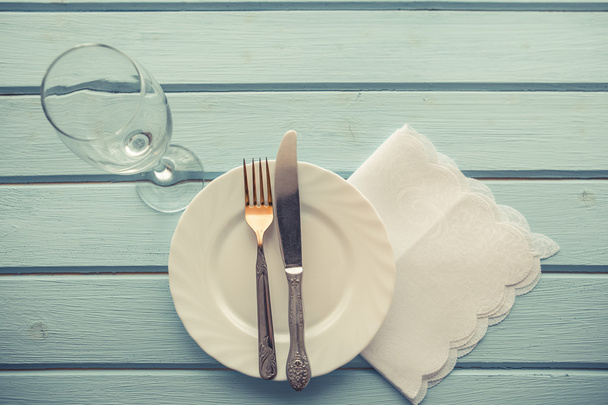 Cuchillo, tenedor y plato sobre mesa de madera
 - Foto, Imagen
