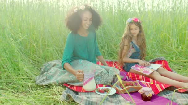 Girls sitting in the field and drinking milk - Video, Çekim