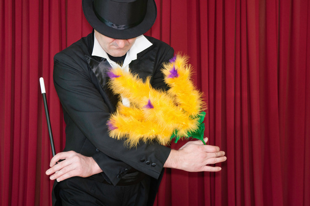 Magician with yellow flowers on stage  - Photo, Image