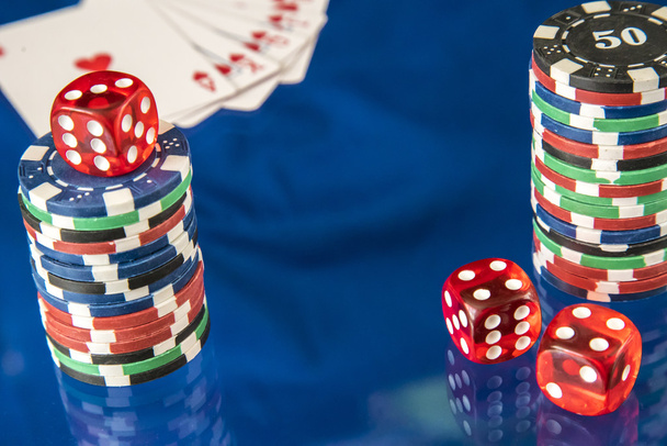 Fichas de juego y tarjeta de póquer sobre fondo espejo azul
 - Foto, imagen