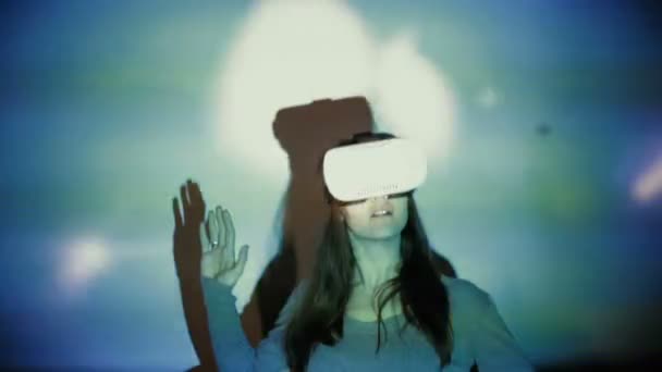 Nainen käyttää VR-kypärää valokeilassa
 - Materiaali, video