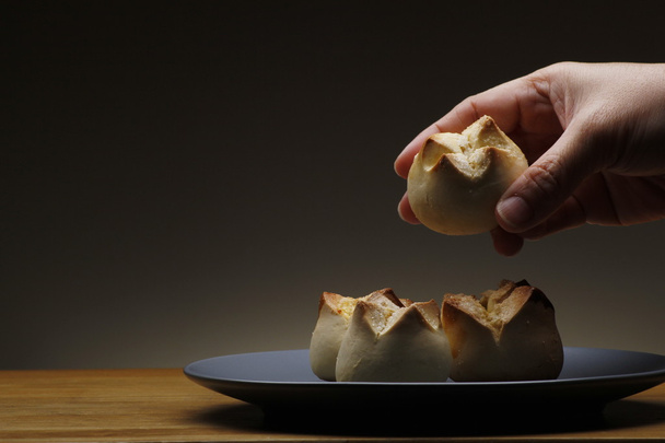 Szerzés egy frissen sült filippínó édes kenyér, úgynevezett "putok"-ból egy halom kéz - Fotó, kép
