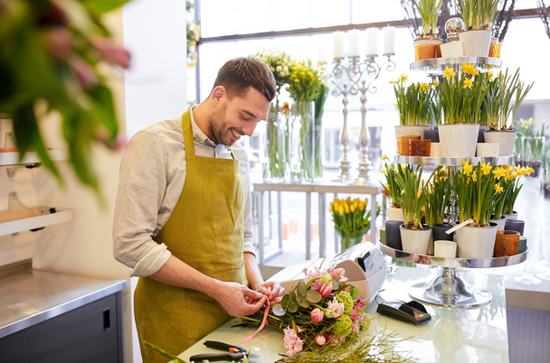 smiling florist man making bunch  - Фото, изображение