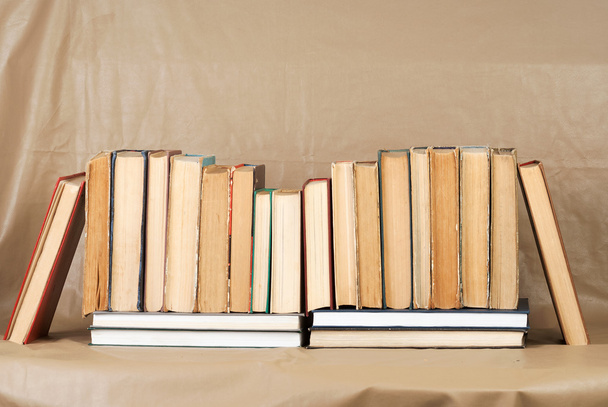 Oude en gebruikte hardback boeken of tekstboeken over houten tafel. Boek en het lezen zijn essentieel voor zelfverbetering, verkrijgen van kennis en succes in onze carrière, zakelijke en persoonlijke leven. Kopiëren van ruimte - Foto, afbeelding