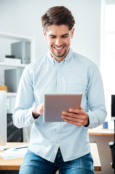 Happy handsome young businessman working and using tablet - Foto, imagen