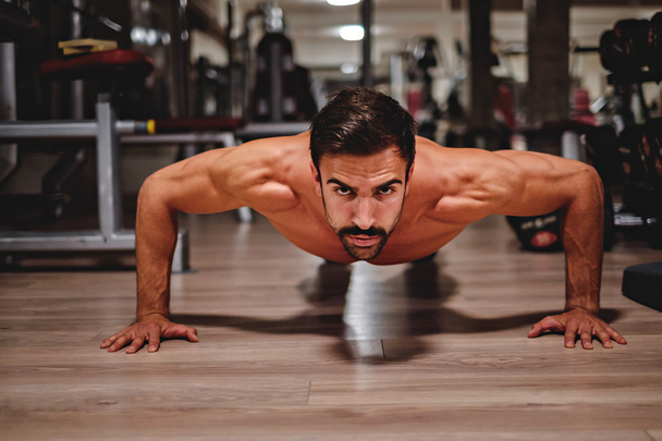 Man doing push ups and looking in front of him - Foto, imagen
