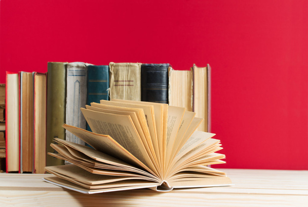 Aufgeschlagenes Buch, Stapel gebundene Bücher auf Holztisch. zurück zur Schule. Kopierraum - Foto, Bild