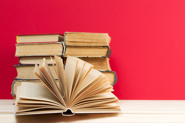 Libro abierto, pila de libros de tapa dura sobre mesa de madera. De vuelta a la escuela. Copiar espacio
 - Foto, imagen