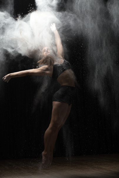 Ballerina dancing with flour on black background - Foto, immagini