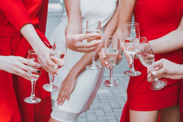 schöne junge Mädchen in roten Kleidern feiern Junggesellenabschied und trinken Champagner - Foto, Bild